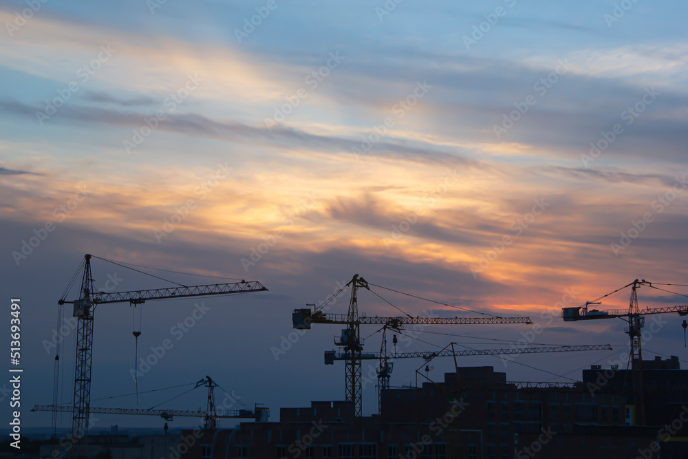 Construction crane and construction site at sunset