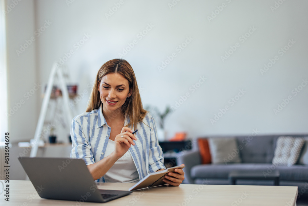 Ambitious businesswoman working alone at the office, holding notebook and pen. Ambitious businesswoman working alone at the office, holding notebook and pen.