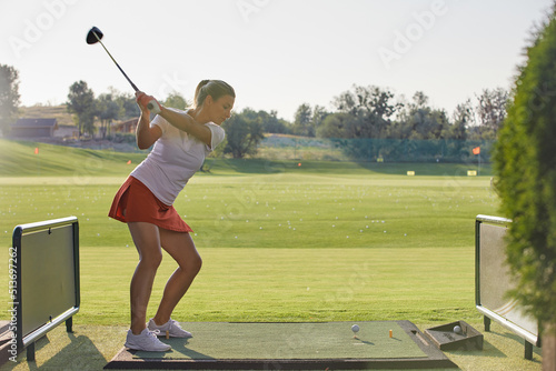 beautiful girl makes a hit while playing golf