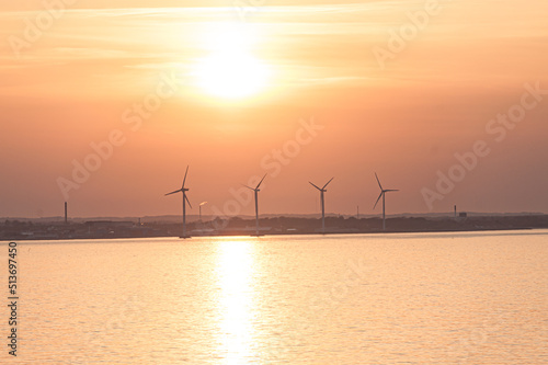 Sun setting over wind turbines on a summer evening..