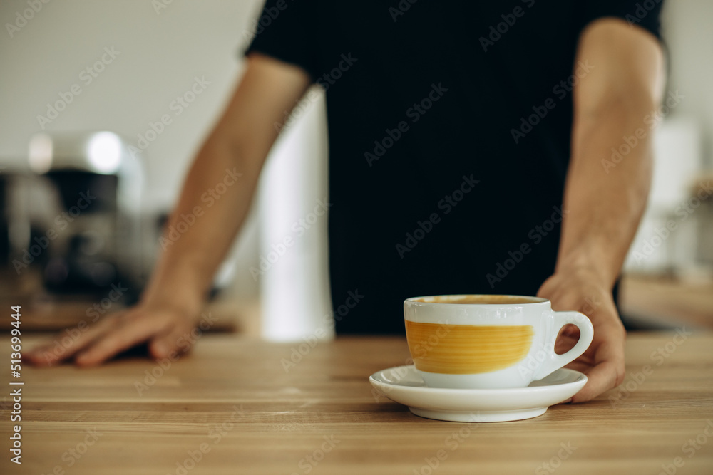 Man at a coffee shop serving cup of cappuccino Man at a coffee shop serving cup of cappuccino