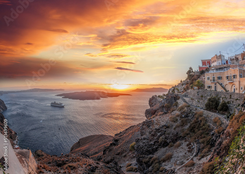 Old Town Thira on the Santorini island, famous churches against caldera with sunset over sea in Greece.