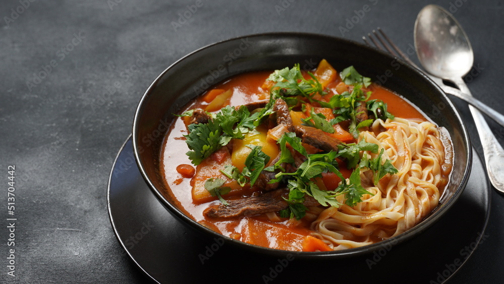 Traditional asian noodle soup with vegetables, potatoes and meat, - lagman. Oriental, uzbek style cuisine Traditional asian noodle soup with vegetables, potatoes and meat, - lagman. Oriental, uzbek style cuisine