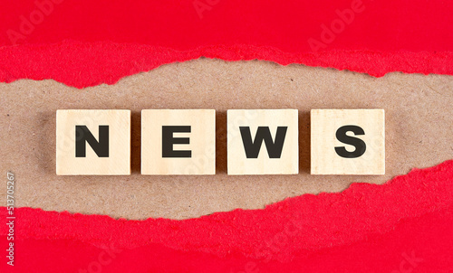 NEWS word on wooden cubes on red torn paper , financial concept background