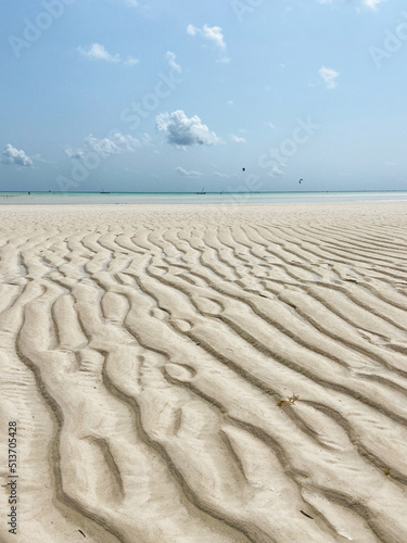 Textura de la arena y de las olas del mar con marea baja en una playa soleada