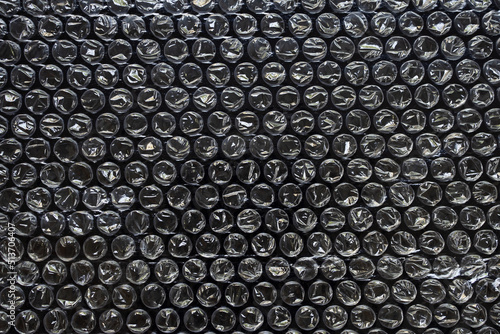 Plastic wrap air bubble packaging material on black background overlay texture