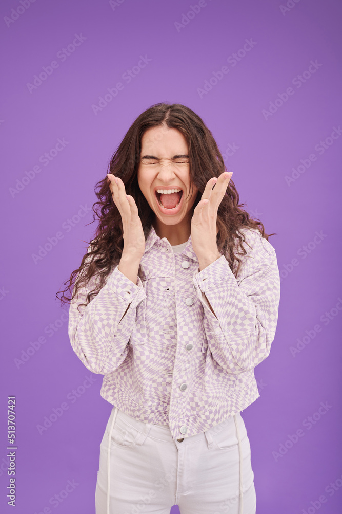 Portrait of young woman expressing her anger and shouting standing against purple background Portrait of young woman expressing her anger and shouting standing against purple background