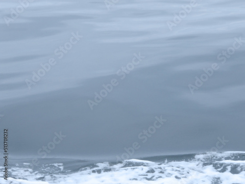 Gray tone calm blue sea surface gradation texture background. Photograph taken from the running fishingboat. 曇天べた凪の海面。