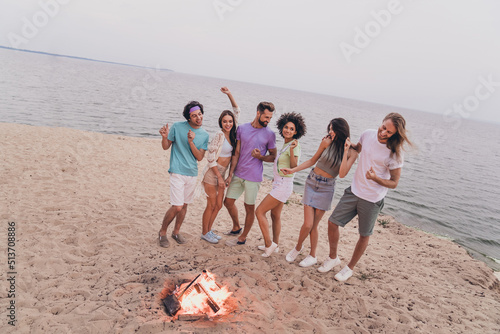 Full size photo of group cheerful buddies enjoy dancing sand beach free time outside #513708886