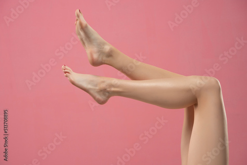 Long pretty smooth woman legs isolated on pink background © vladimirfloyd