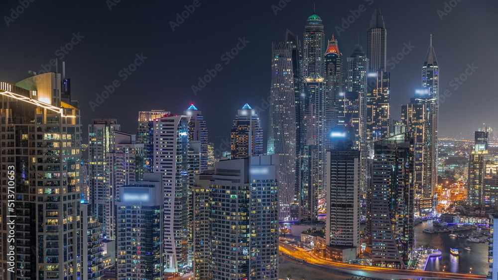 Naklejka premium View of various skyscrapers in tallest recidential block in Dubai Marina aerial night timelapse