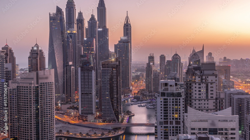 Naklejka premium View of various skyscrapers in tallest recidential block in Dubai Marina aerial night to day timelapse