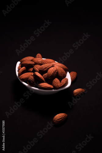 close up some almonds in bowl in dark background photo