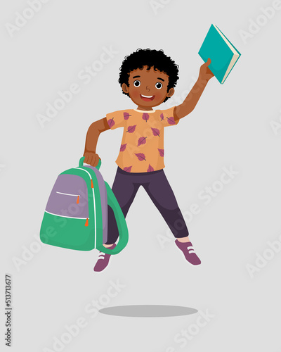 Happy little African boy student with backpack holding book and pen jumping feeling excited to be back to school