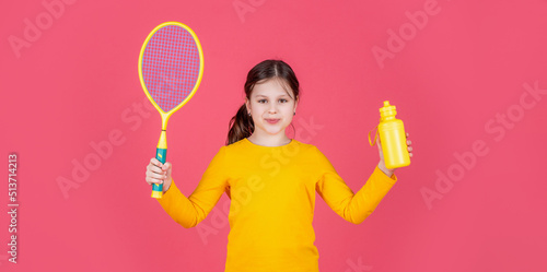 cheerful kid hold tennis racket and water bottle on pink background