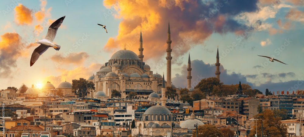 Obraz premium Beautiful view of gorgeous historical Suleymaniye Mosque, Rustem Pasa Mosque and buildings in front of dramatic sunset. Istanbul most popular tourism destination of Turkey. Travel Turkey concept.