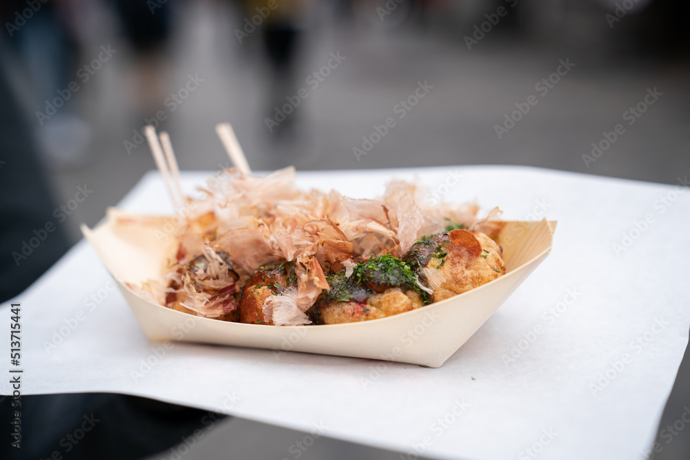 freshly cooked takoyaki ballshaped octopus dumpling served in a paper