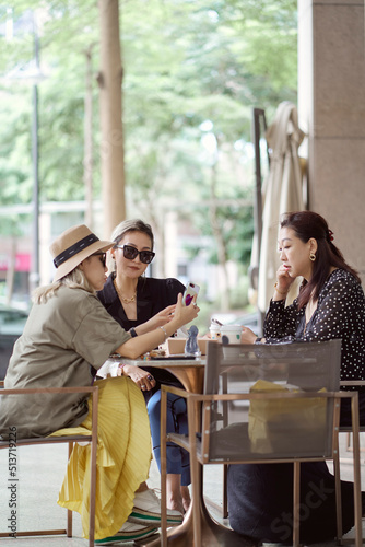Asian women sitting and chatting  outdoors at coffee shop