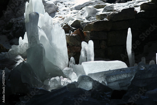 Ice stalagmites in an underground cave. Ice formations in the dark. Mountain places in winter.