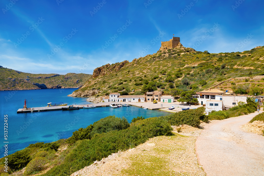 View of the dock of the port of Cabrera with the castle on top of a hill that presides over the bay. Balearic Islands, Spain