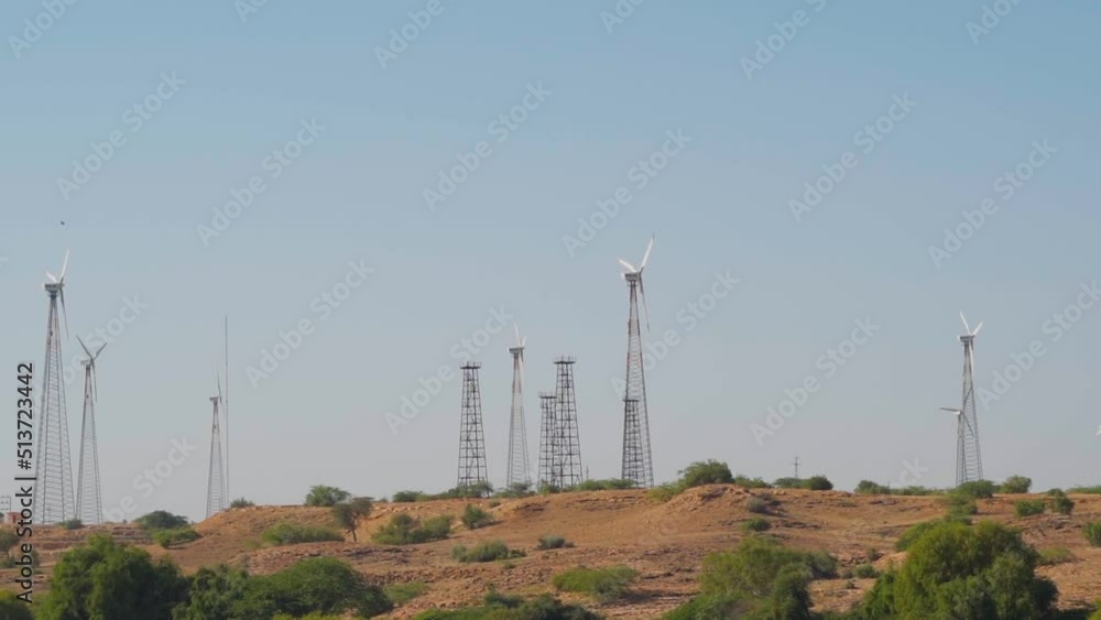 Windmills in a windfarm as seen from the Bada Bagh at Jaisalmer in Rajasthan, India. Wind Power Turbines Generating Clean Renewable Energy for Sustainable Development. Concept of using clean energy. Windmills in a windfarm as seen from the Bada Bagh at Jaisalmer in Rajasthan, India. Wind Power Turbines Generating Clean Renewable Energy for Sustainable Development. Concept of using clean energy.
