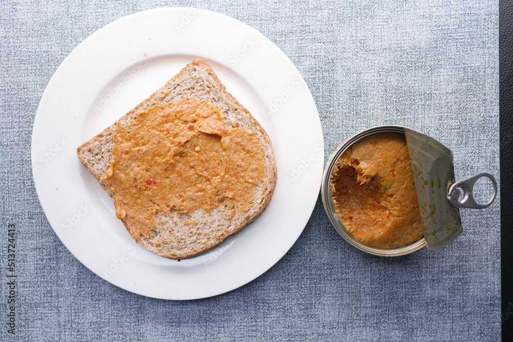 spreading canned tuna on a toasted bread spreading canned tuna on a toasted bread
