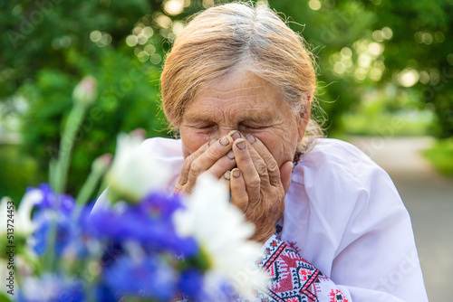 The old woman is allergic to flowers. Selective focus.