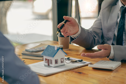 The real estate agent discusses the terms of the home purchase contract and asks the client to sign the documents to legally enter the contract. Ideas for selling a house at an office desk