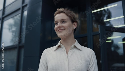 Portrait smiling teacher welcoming pupils at campus. Woman nodding to children.