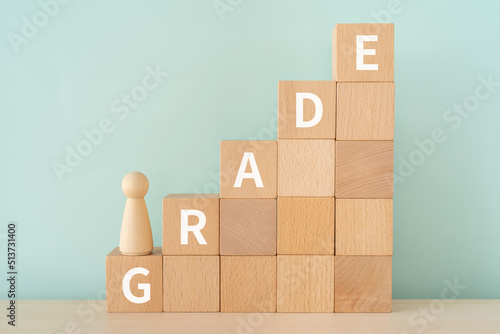 階級・グレードのイメージ｜「GRADE」と書かれたブロックと人形