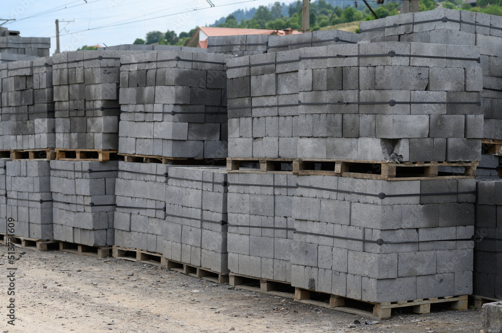 White brick for construction. Cinder blocks stacked on pallets were purchased for the construction of a house in the countryside. White brick for construction. Cinder blocks stacked on pallets were purchased for the construction of a house in the countryside.