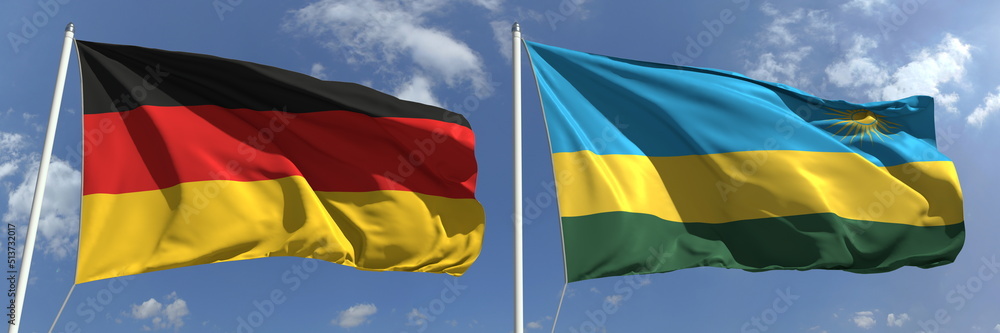 Naklejka premium Flags of Germany and Rwanda on flagpoles. 3d rendering