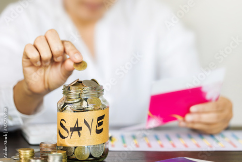 woman picking up a coin for save money and holding a bank account in hand, saving money or savings concept.