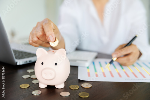 pig piggy bank on the table and woman calculating financial accounts for save money, saving money or savings concept.