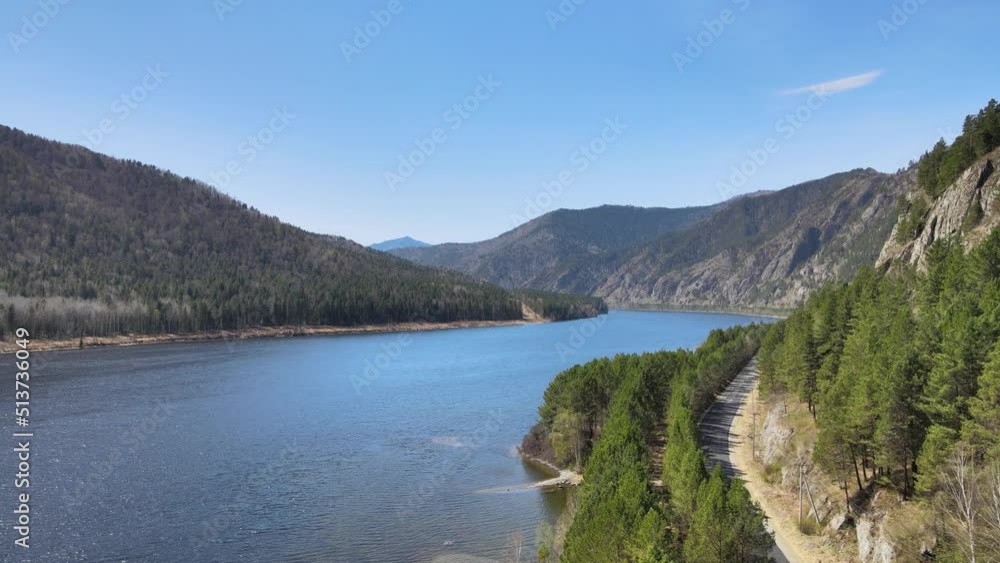 Drone flight over a river with a shore and a road on a sunny day Drone flight over a river with a shore and a road on a sunny day