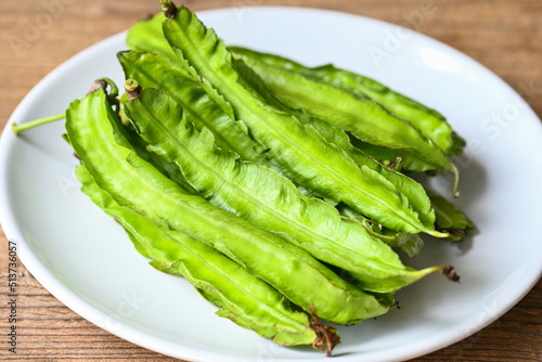 Winged Bean on white plate background, Psophocarpus tetragonolobus - Green winged or Four angle beans