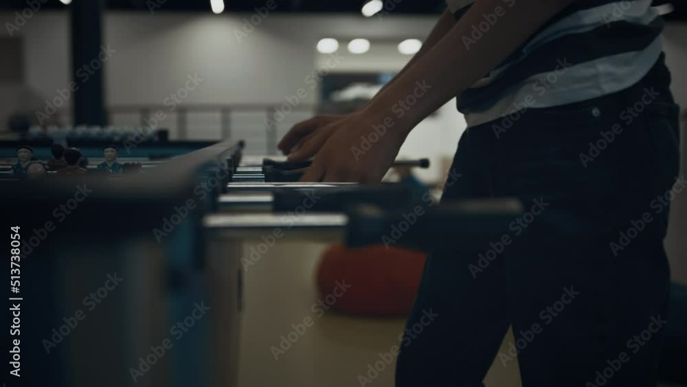 Energetic boy hands playing table football close up. Schoolboy enjoying game. Energetic boy hands playing table football close up. Schoolboy enjoying game.