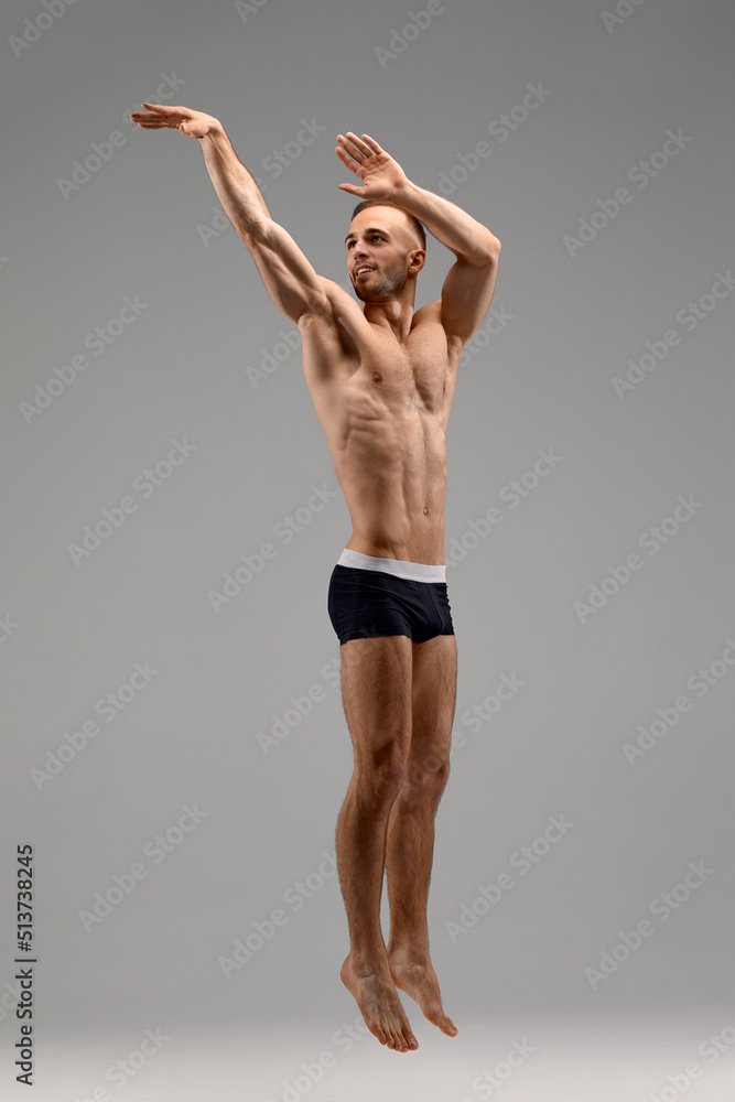 In jump. Caucasian professional sportsman training isolated on white studio background. Muscular, sportive man practicing. Copyspace. Concept of action, motion, youth, healthy lifestyle.