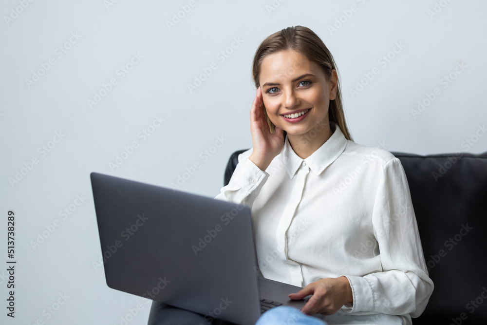 Pretty woman using laptop sitting on cosy sofa Pretty woman using laptop sitting on cosy sofa