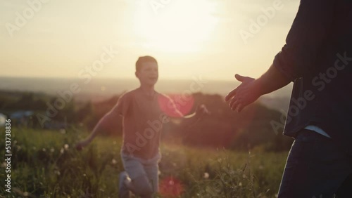 Little boy running for dad at the meadow during the sunset. Shot with RED helium camera in 4K.  
