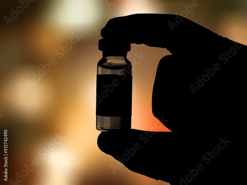 Vaccine concept. Medical hand black silhouette showing bottle with vaccine.
