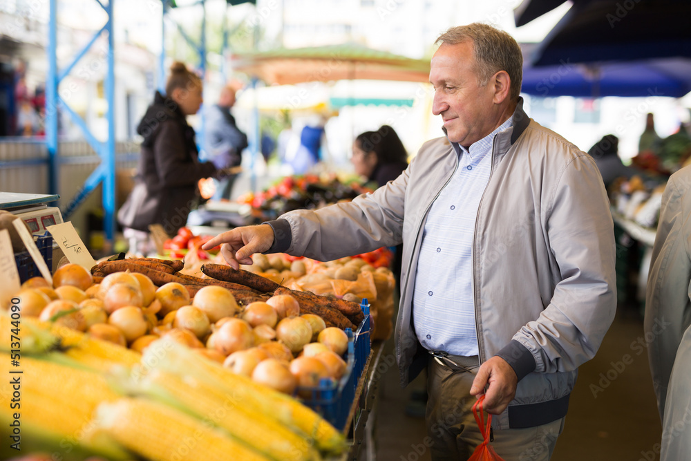Man choosing vegetables in greengrocery