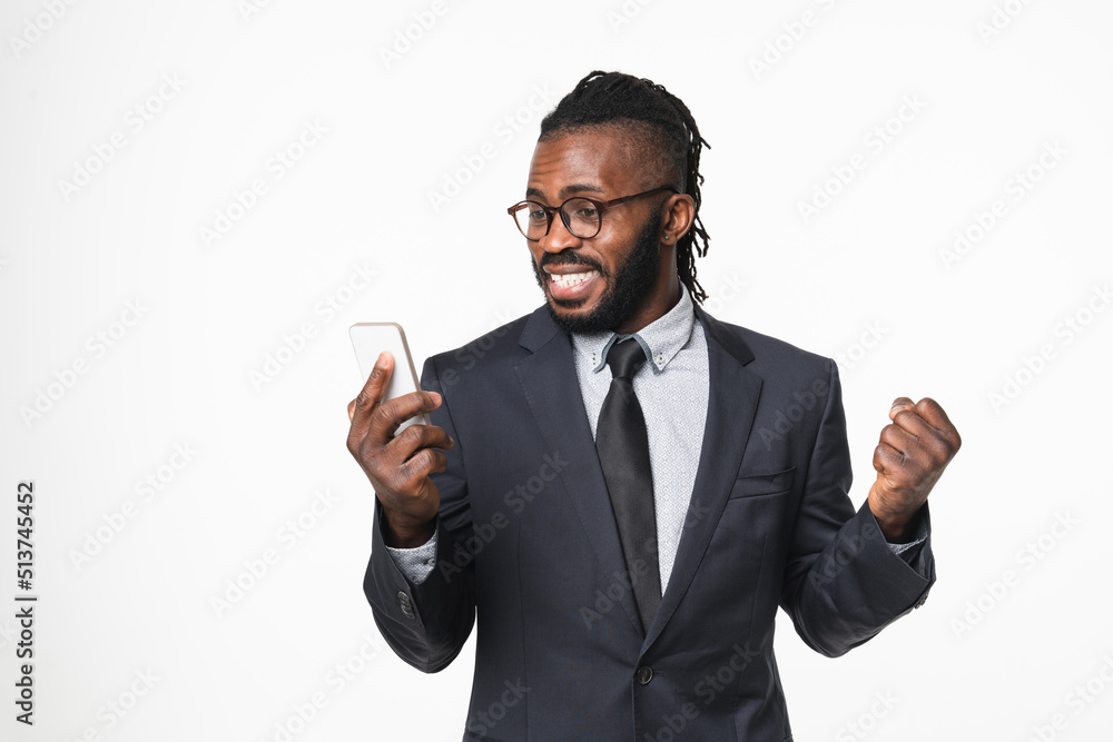 Successful happy african businessman ceo boss leader bank employee winning money on online bets, casino, cashback on cellphone isolated in white background Successful happy african businessman ceo boss leader bank employee winning money on online bets, casino, cashback on cellphone isolated in white background