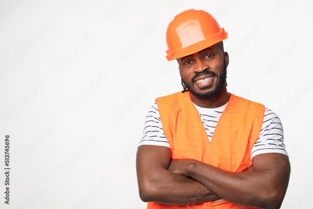 African-american young man construction worker engineer architect in reflective orange vest and hardhat with arms crossed isolated in white background African-american young man construction worker engineer architect in reflective orange vest and hardhat with arms crossed isolated in white background