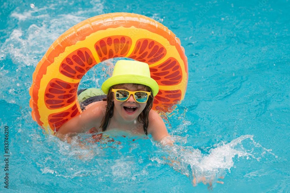 Kid in sunglasses in pool in summer day. Children playing in swimming pool. Summer holidays and vacation concept.