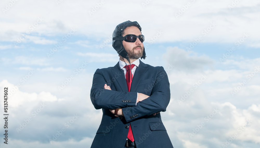 confident businessman in suit and pilot hat on sky background confident businessman in suit and pilot hat on sky background