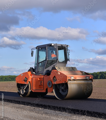 roller laying fresh asphalt . Road works with excavators. Construction of new roads on the highway in the field 