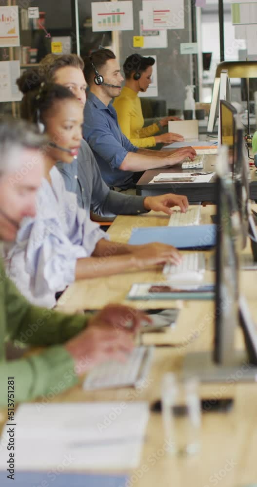 Vertical video of diverse business people working with phone headsets at office Vertical video of diverse business people working with phone headsets at office