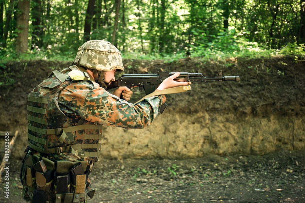 The Ukrainian military in a bulletproof vest shoots from the machine gun The Ukrainian military in a bulletproof vest shoots from the machine gun