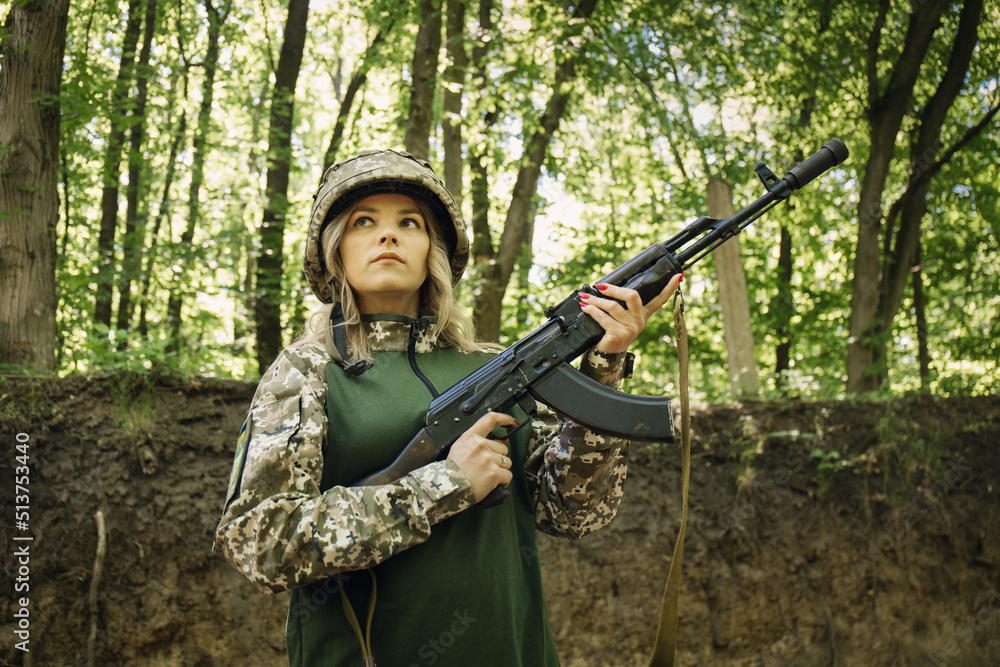 Portrait of a Ukrainian military woman with with assault rifle Akm